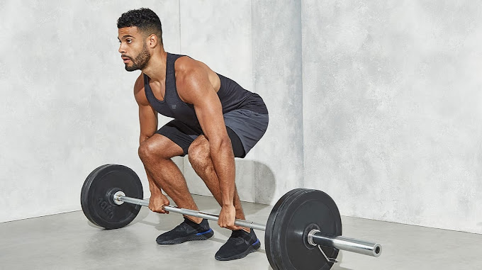 A man squats with a barbell in front of him