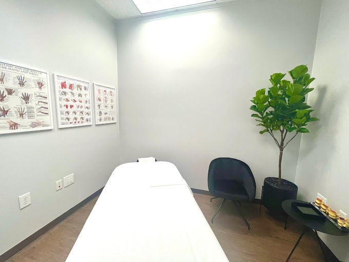 A room with a bed, chair and a potted plant