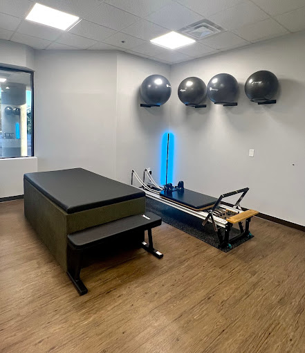 A room with a row of exercise equipment on the floor